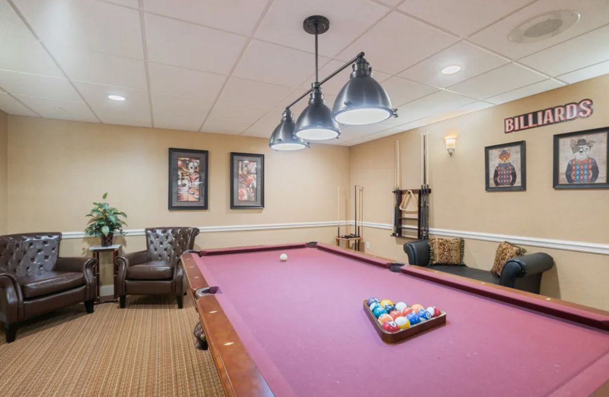 A cozy game room with a pool table, comfortable seating, and stylish decor.