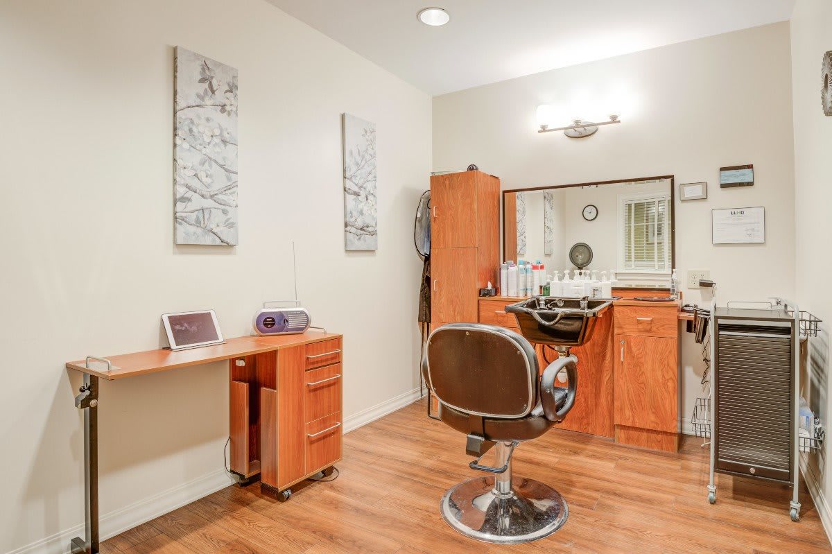 A well-organized hair salon interior with a styling chair and mirror.