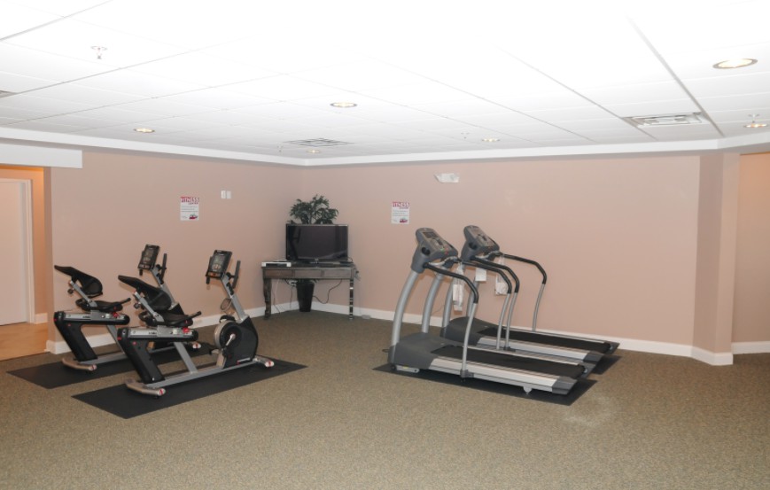 A small gym room equipped with treadmills and exercise bikes.
