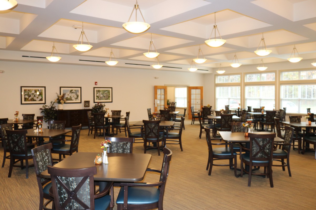An empty dining room with neatly arranged tables and chairs.