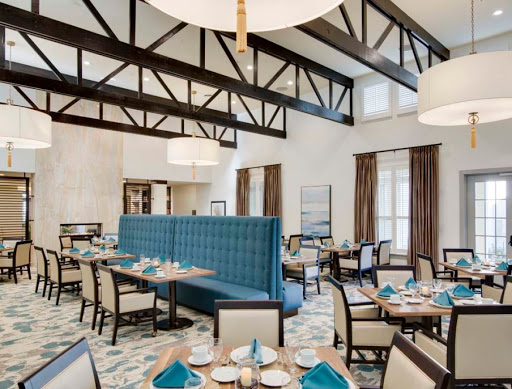A modern dining area featuring spacious seating, blue accents, and stylish decor.