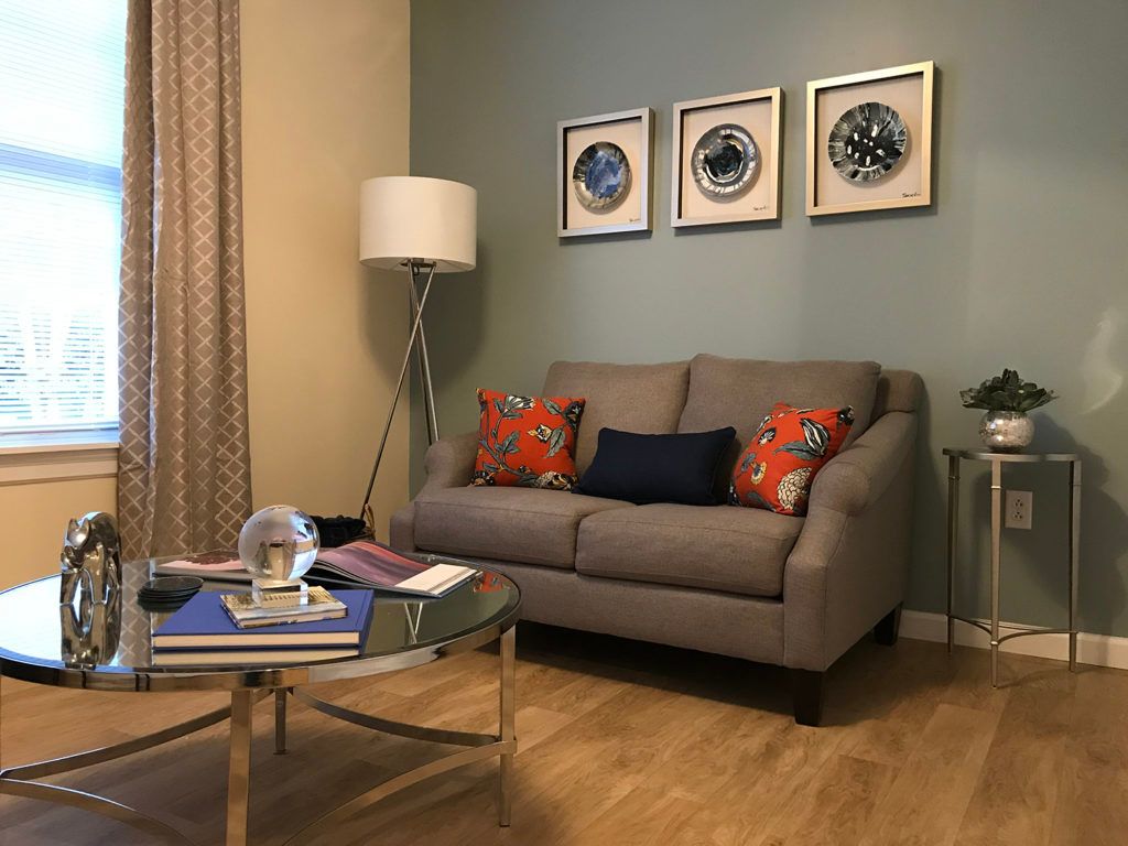 A cozy living room with a grey sofa, stylish wall art, and modern decor.