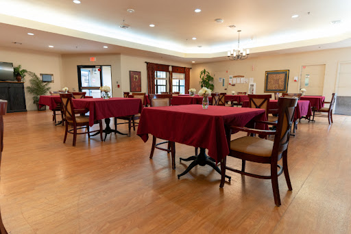 A cozy dining area with red tablecloths and wooden floors, ready for guests.
