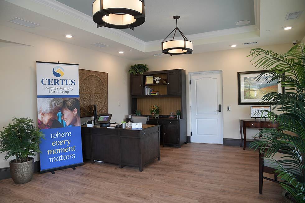 Modern office reception area with a desk, banner, and decorative lighting.