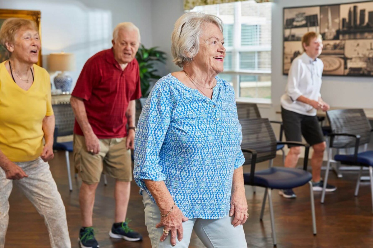 A group of seniors participating in an indoor exercise class.