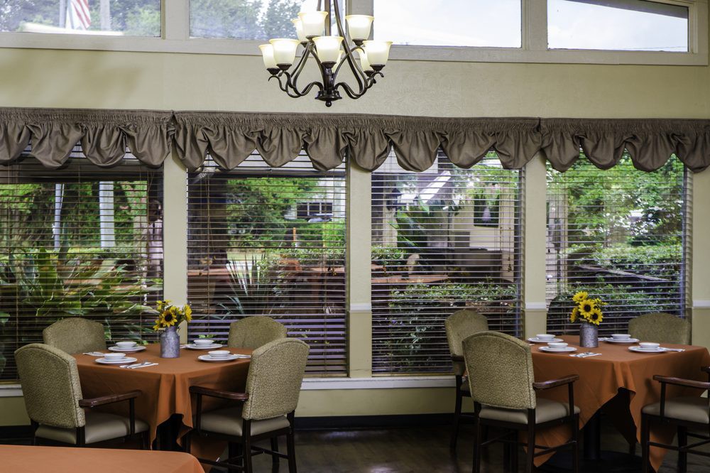 A cozy dining room with large windows and elegant decor.