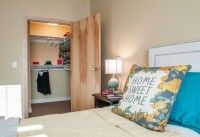 Cozy bedroom with a 'Home Sweet Home' pillow and open closet.