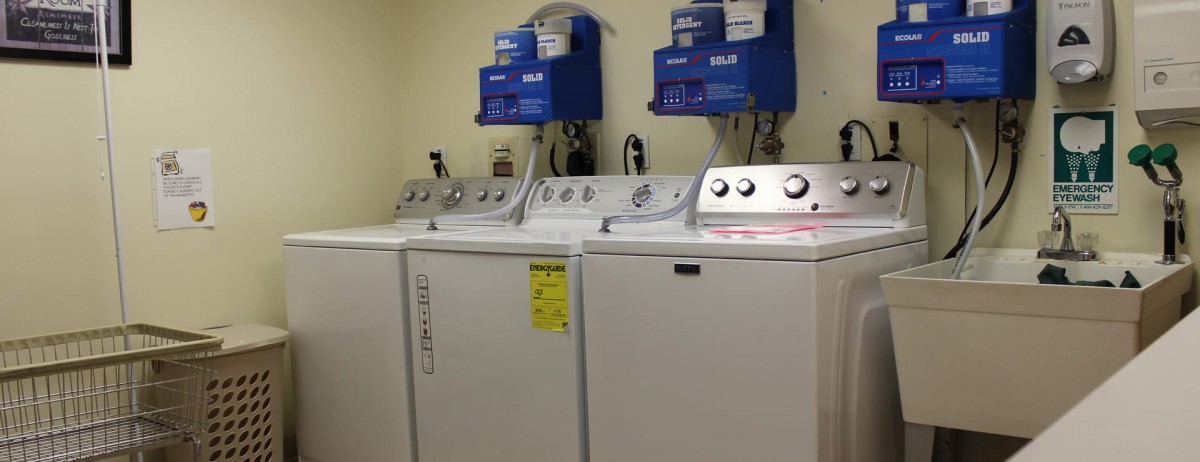 A row of washing machines in a laundromat setting.