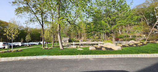 A peaceful park scene with lush greenery and a wooden bridge.