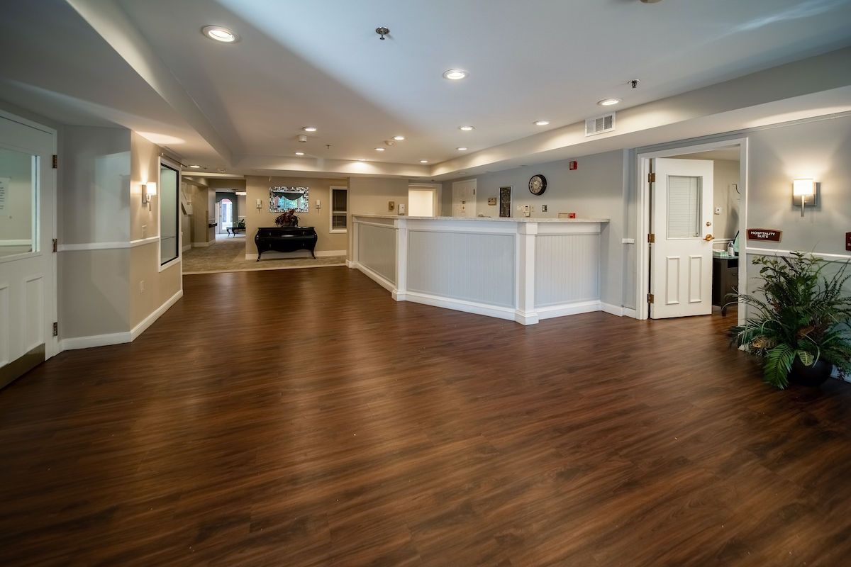 A spacious office lobby with wooden flooring and modern lighting.