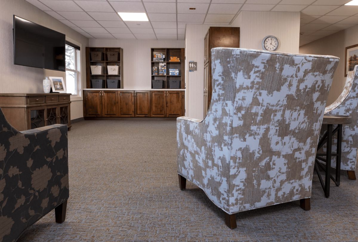 A cozy lobby area with chairs and bookshelves.