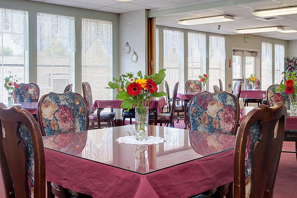 A cozy dining room with a table adorned with a vibrant floral centerpiece.