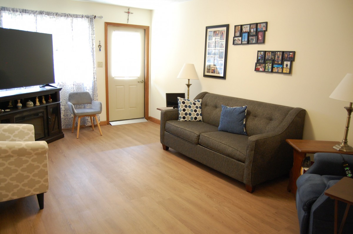 A cozy living room with a sofa, chair, and decorative wall art.