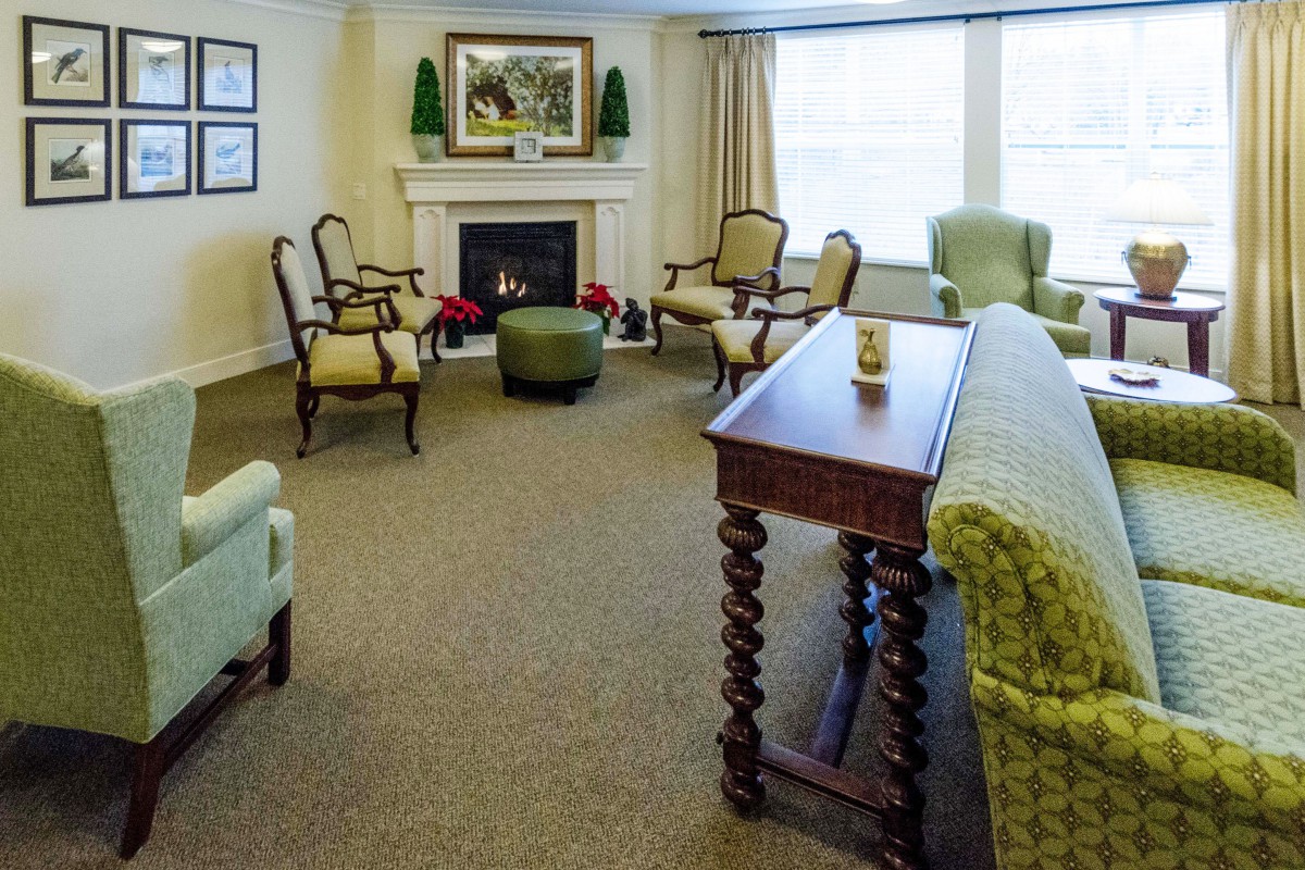 A cozy living room with a fireplace, classic furniture, and warm lighting.