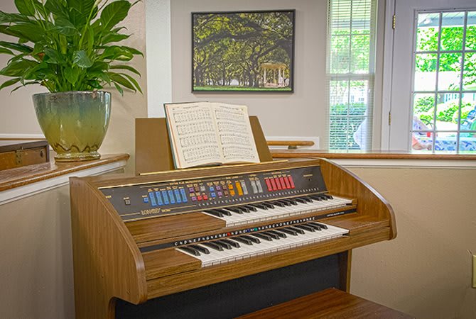 A vintage organ with sheet music displayed in a cozy room setting.