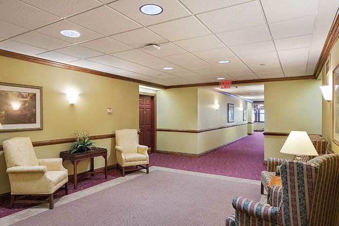 A well-lit hallway with seating and carpeting.