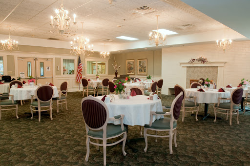 An elegant dining room featuring beautifully set tables and chandeliers.