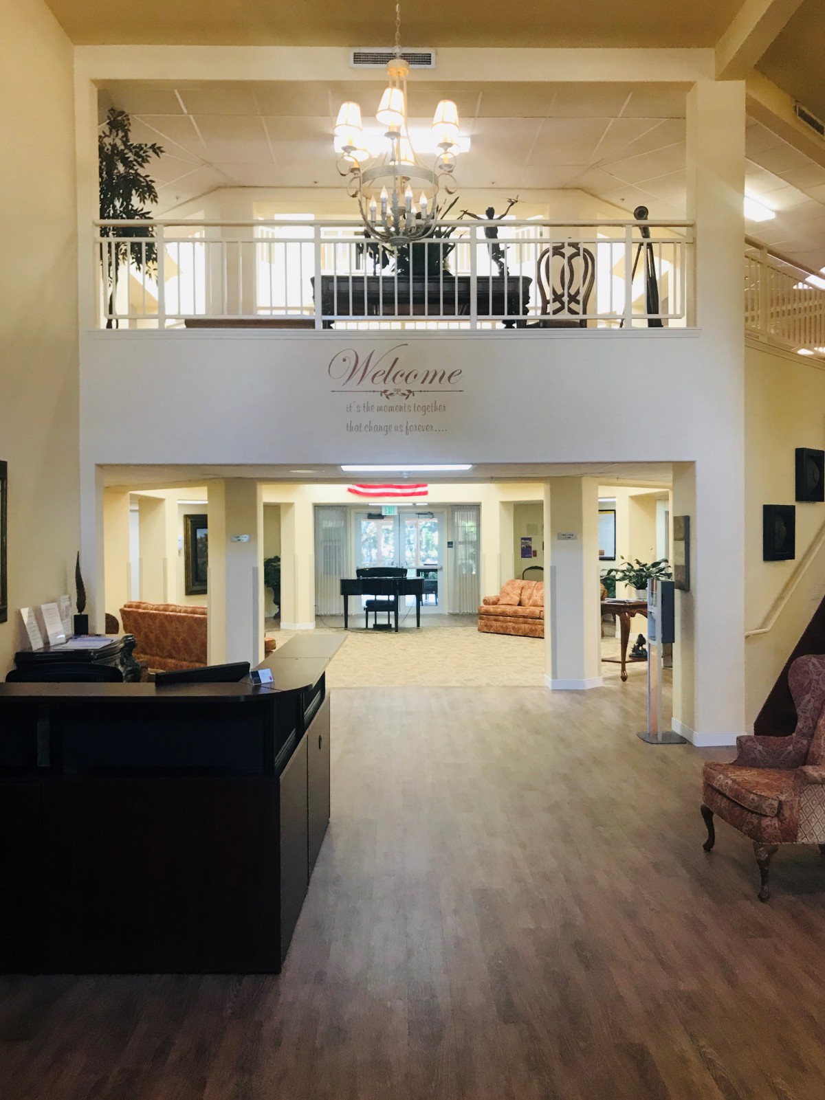 A spacious and elegantly designed lobby with a grand piano, chandelier, and comfortable seating.
