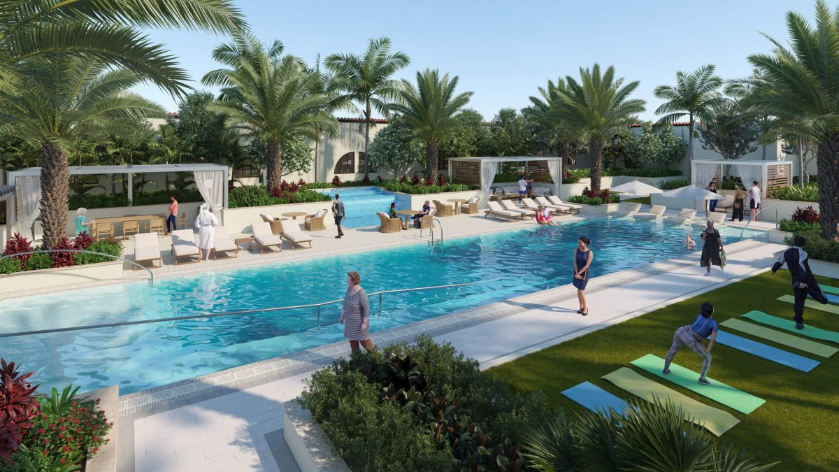 A relaxing outdoor pool area surrounded by palm trees, with people enjoying the sunny weather.