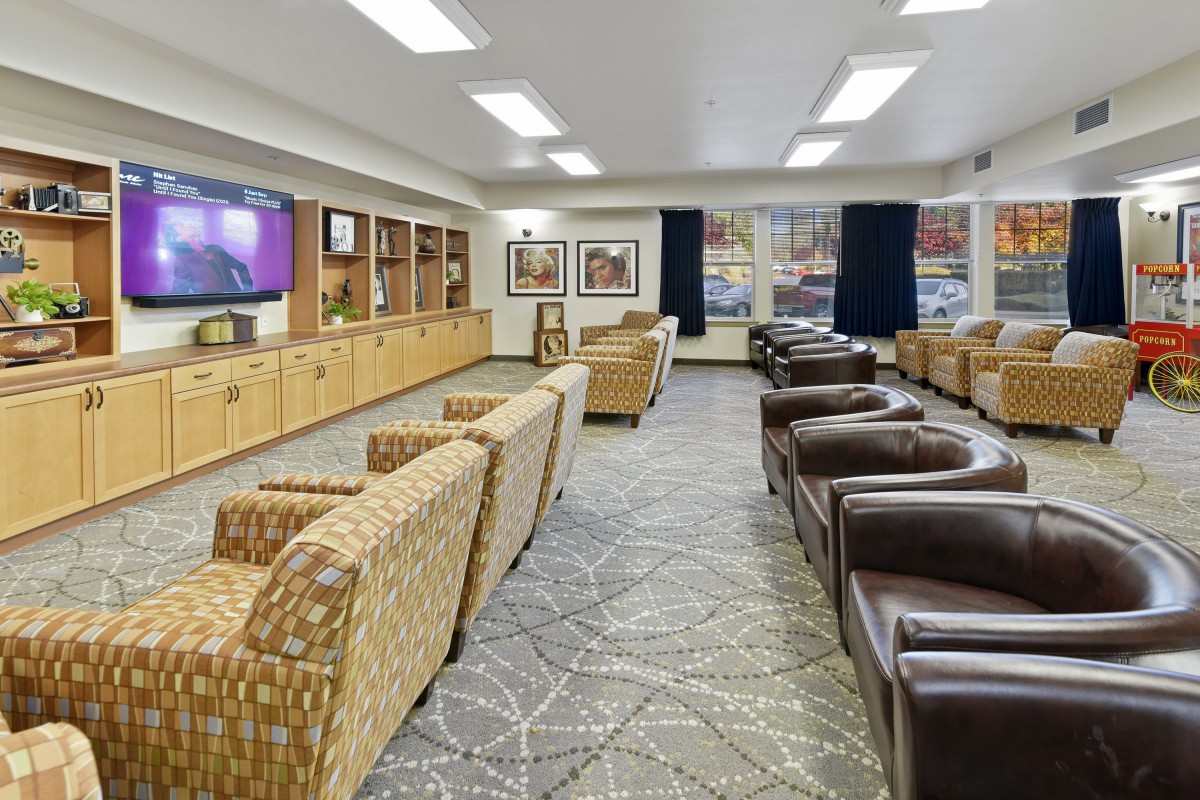 A spacious lounge area with comfortable seating and a large television.