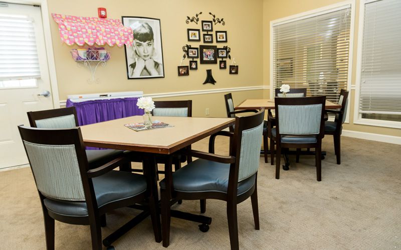 A cozy dining area featuring tables and chairs, with wall art adding a touch of decor.
