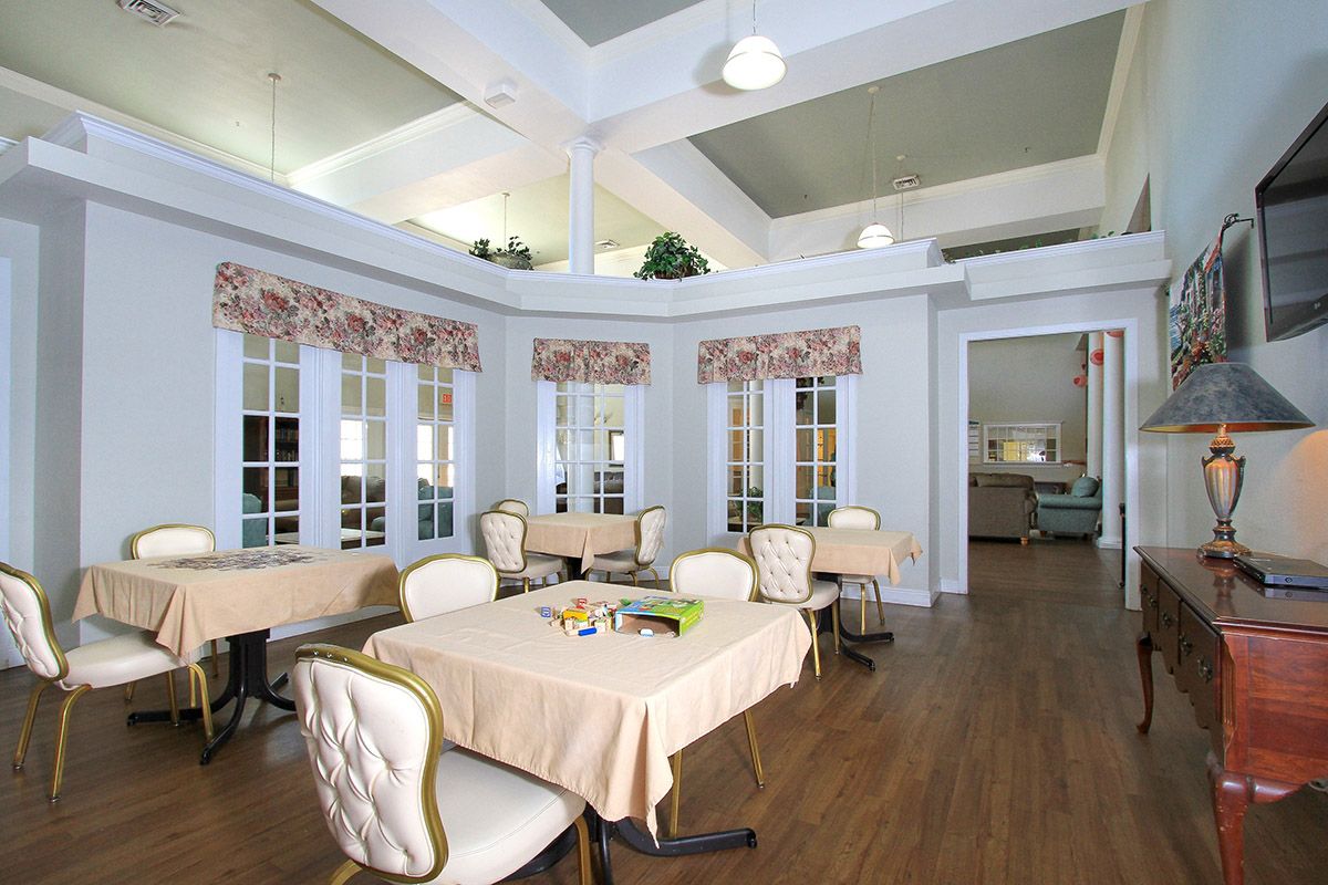 A beautifully designed dining room with tables and chairs, featuring large windows and elegant decor.