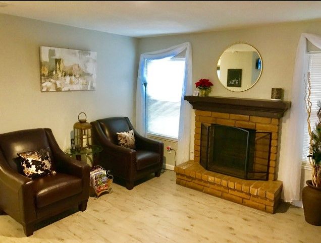 Cozy living room with comfortable armchairs and a brick fireplace.