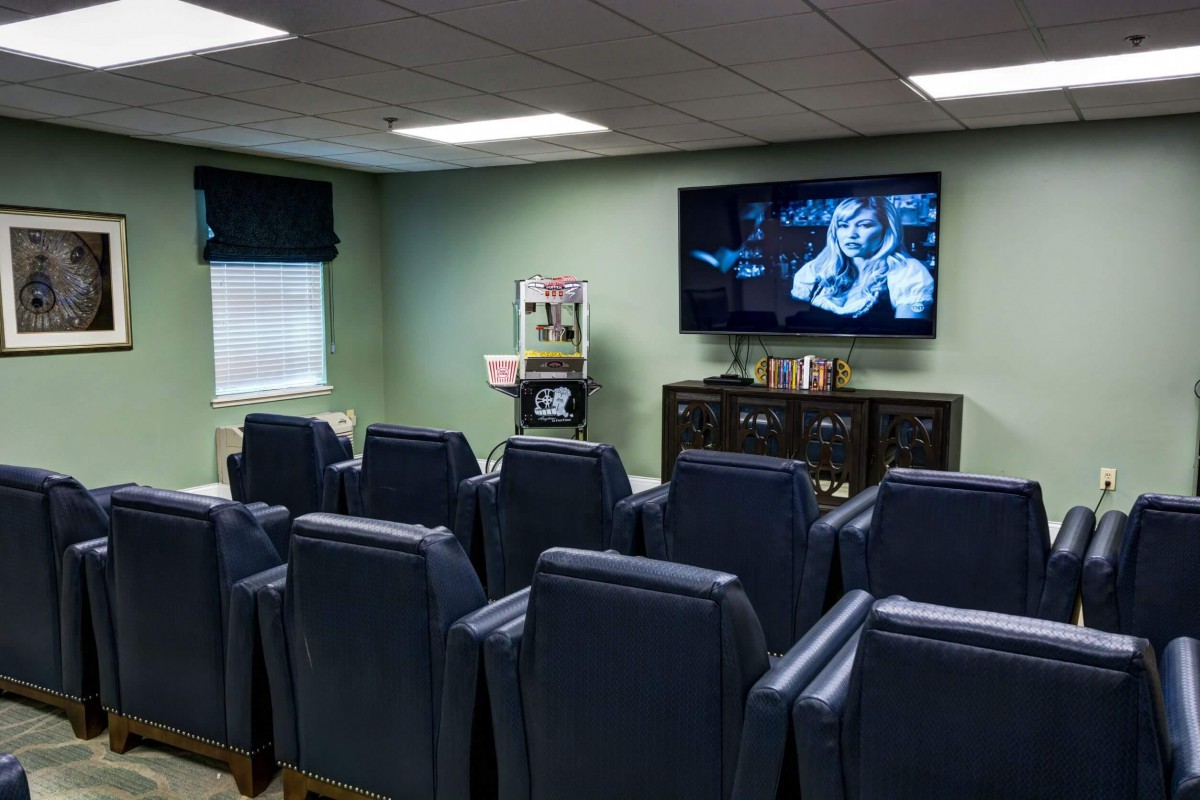 A cozy home theater room with several comfortable chairs arranged in rows facing a large television screen, perfect for watching movies.