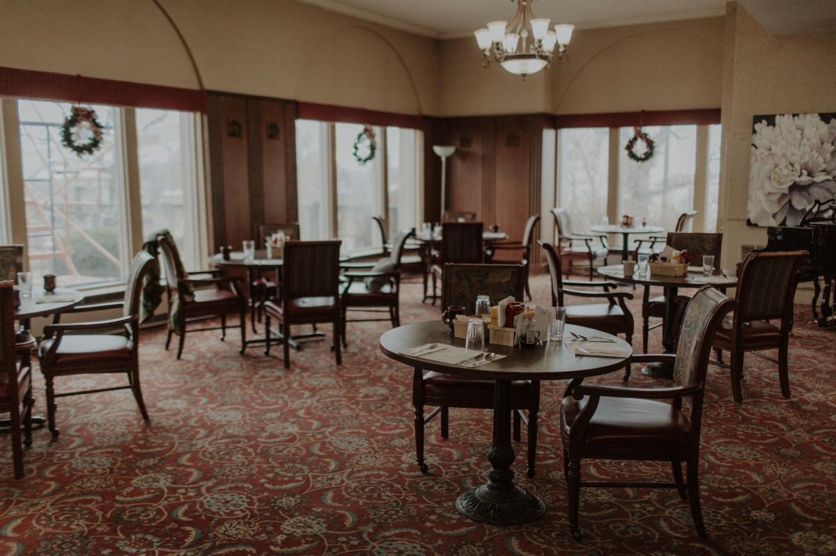 A cozy dining room with elegantly set tables and large windows.