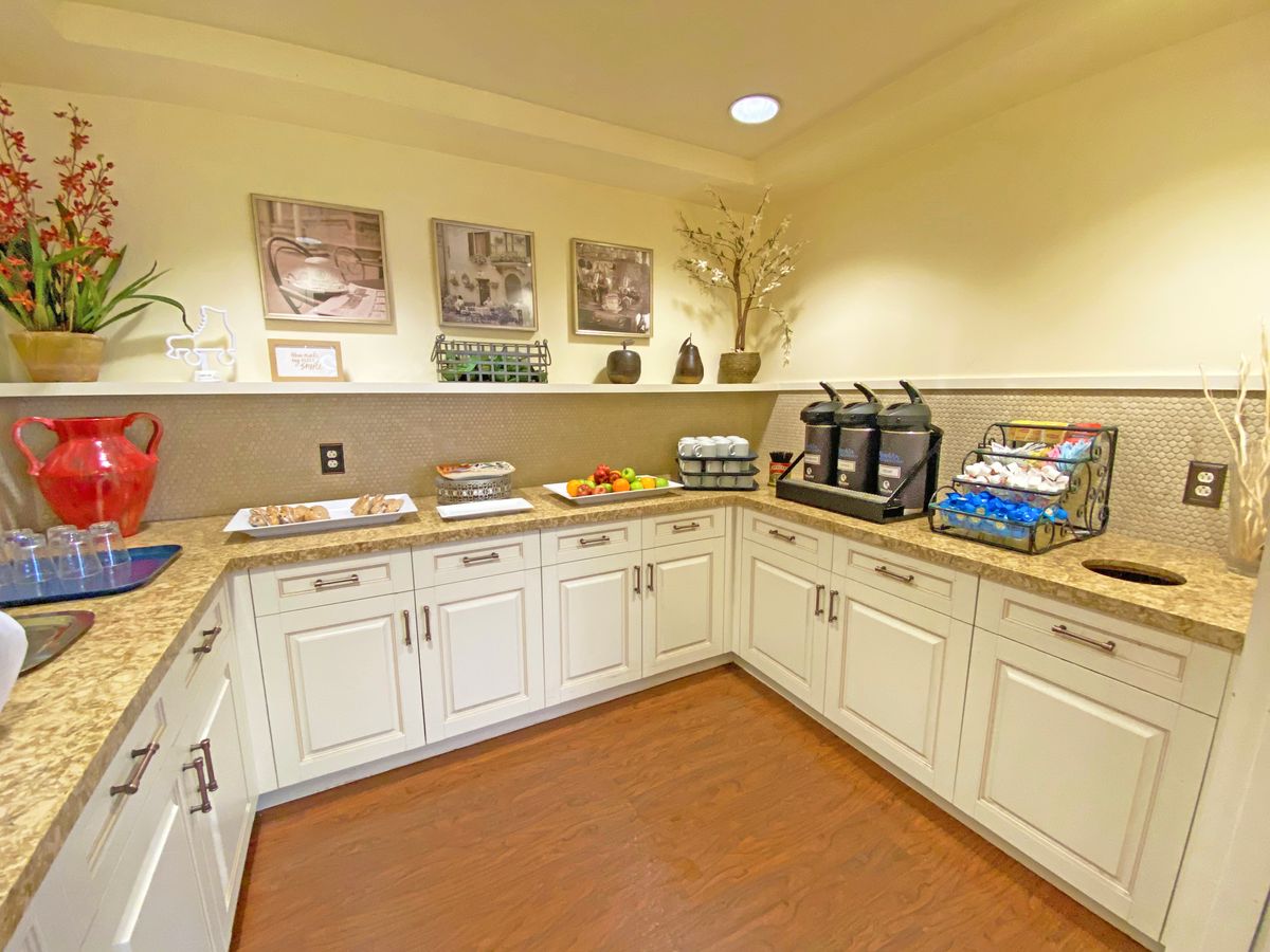 A well-organized kitchenette featuring a coffee station with beverage dispensers, snacks, and ample countertop space.