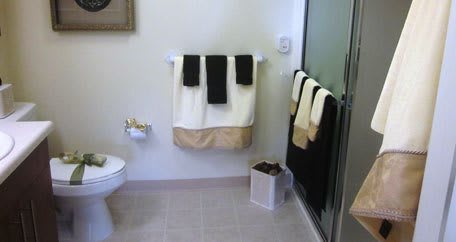 A neatly arranged bathroom with towels and a shower area.