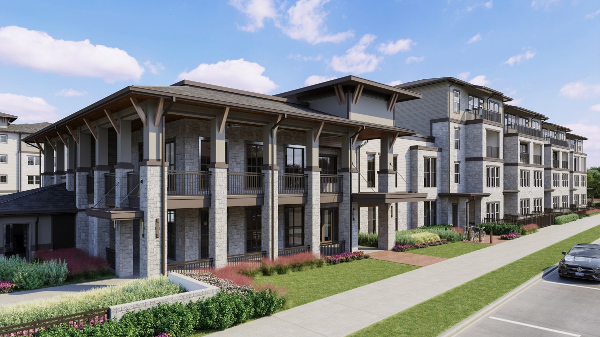 A modern residential apartment building with landscaped surroundings and a clear blue sky.