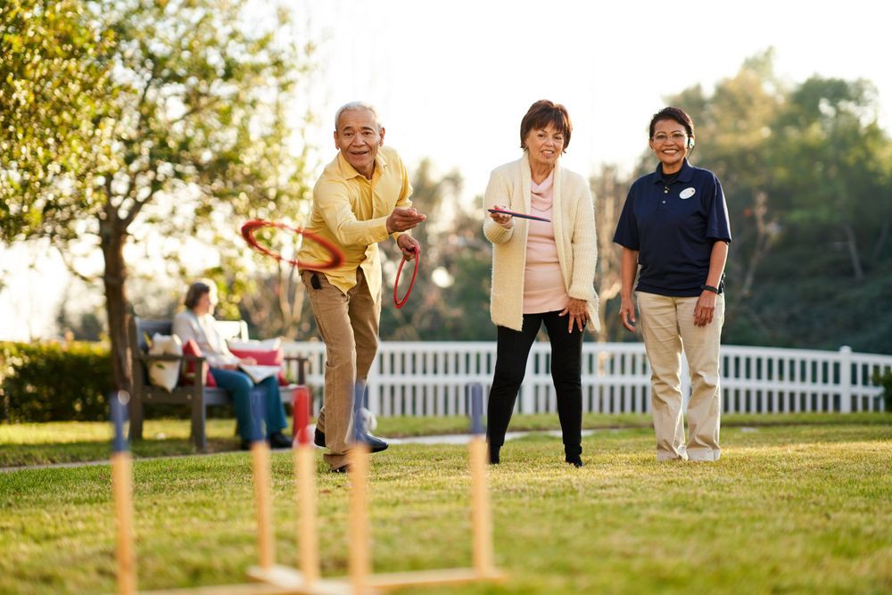 A group of adults enjoying a game of croquet on the lawn during a sunny day.