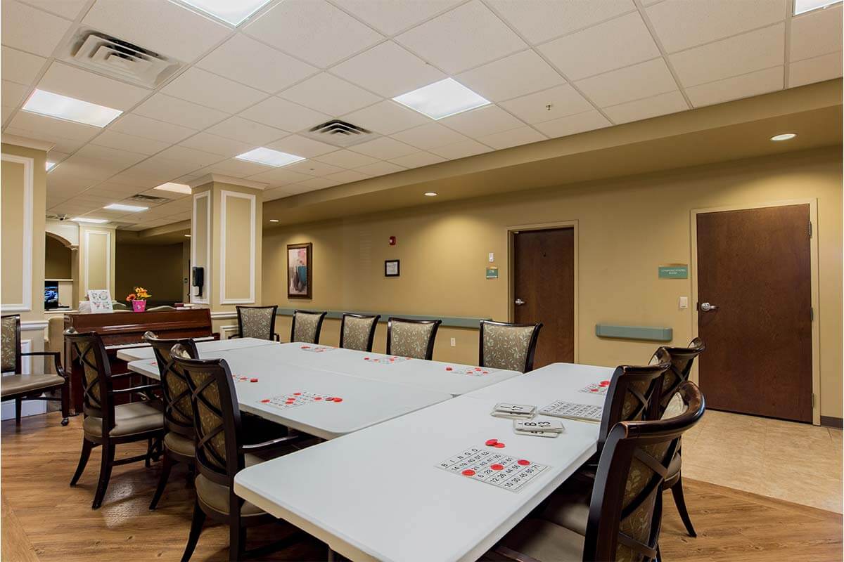 A large conference room with white tables and several chairs arranged for a meeting.