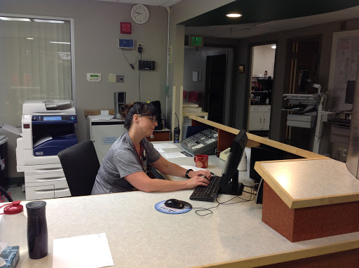 A staff member working at a reception desk in an office environment.