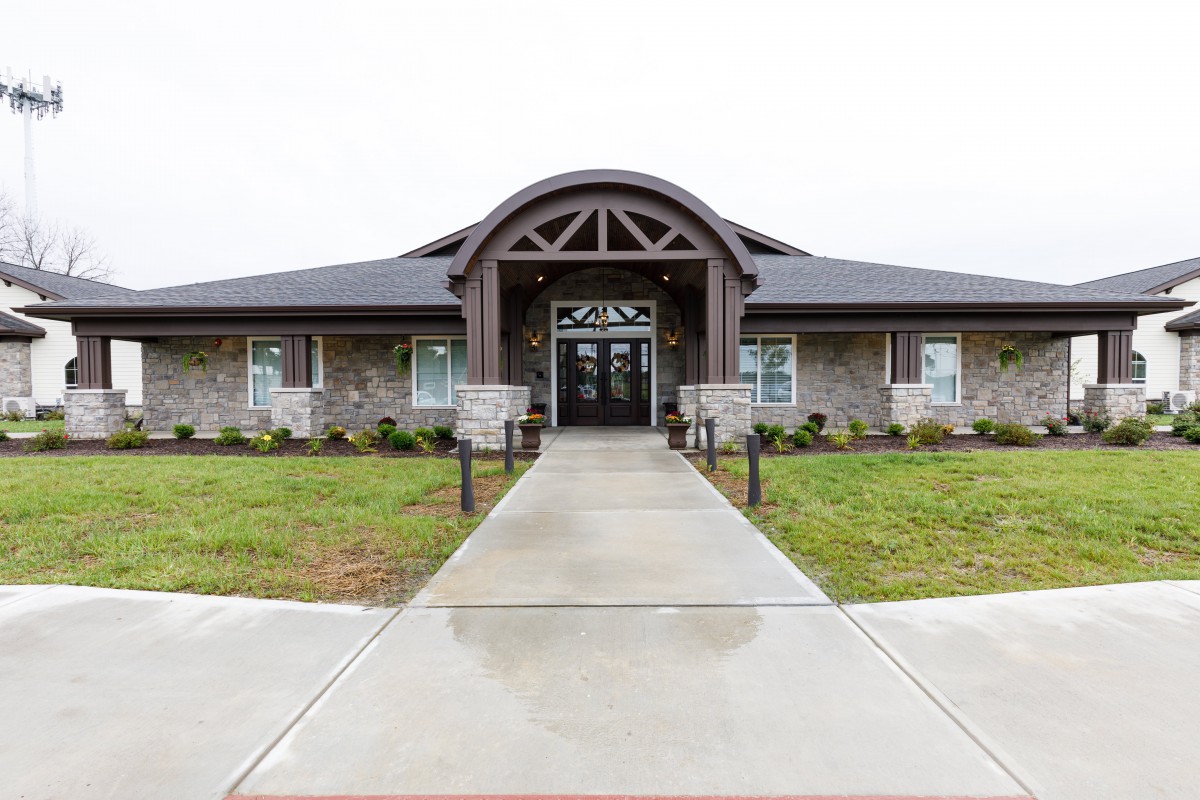 A modern building with an arched entrance and landscaped surroundings.