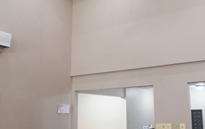 A minimalist interior with beige walls and a door leading to another room.