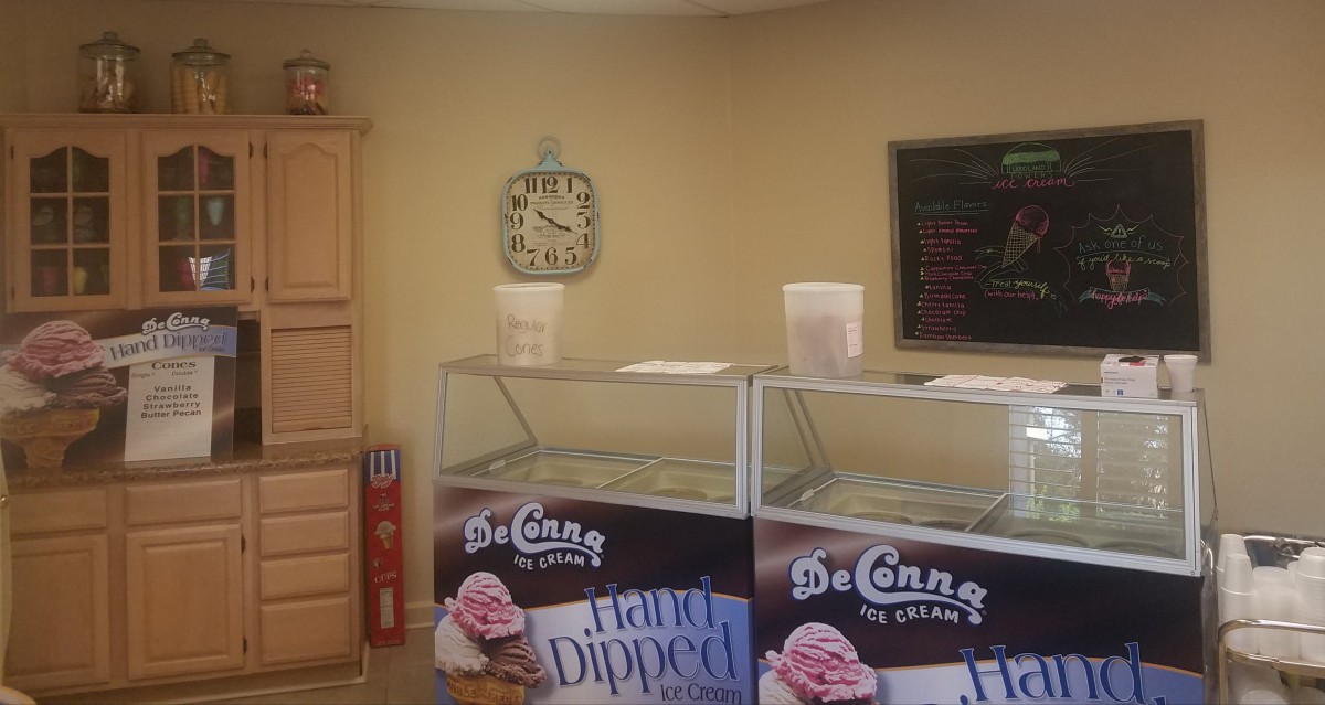 Interior of an ice cream shop featuring display cases and a menu board.