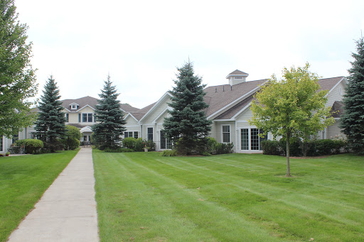 A charming residential building surrounded by well-maintained lawns and trees.