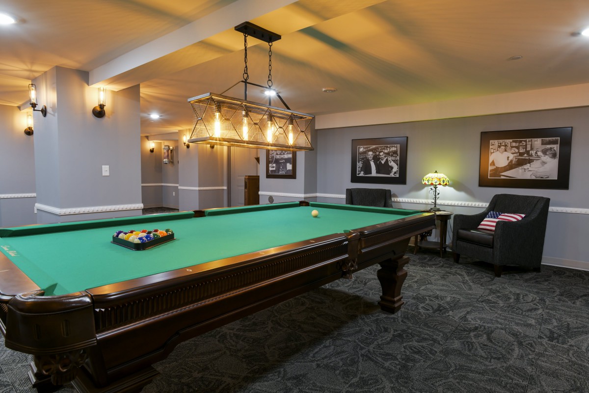 A stylish recreation room featuring a pool table and elegant lighting.