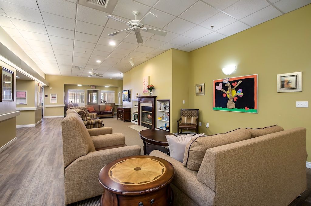 A cozy living room with comfortable seating and colorful artwork on the wall.