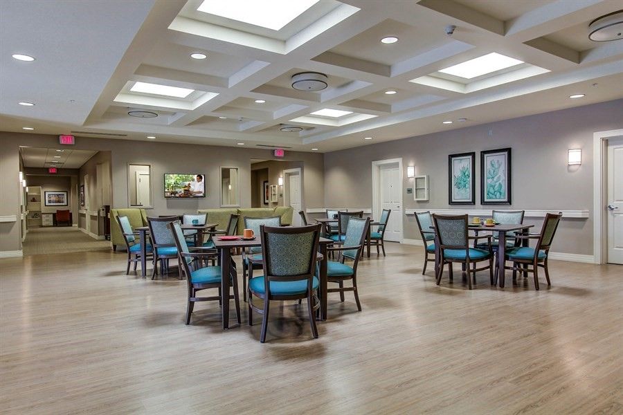A modern dining area with neatly arranged tables and chairs under bright lighting.