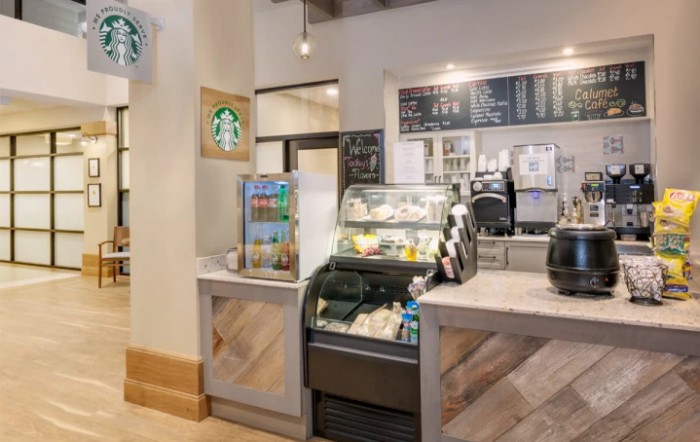 Interior view of a Starbucks coffee shop with a menu board and pastry display.