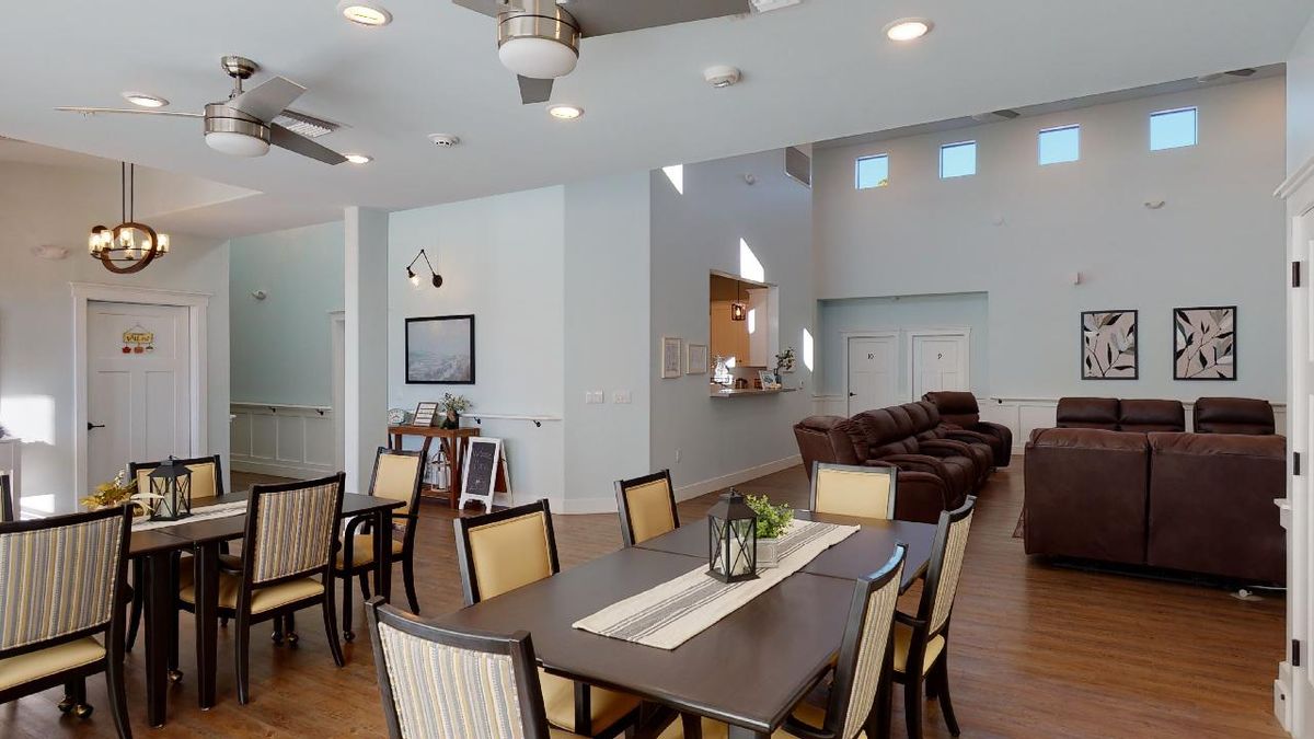 A modern dining and living area with stylish furniture and wood flooring.