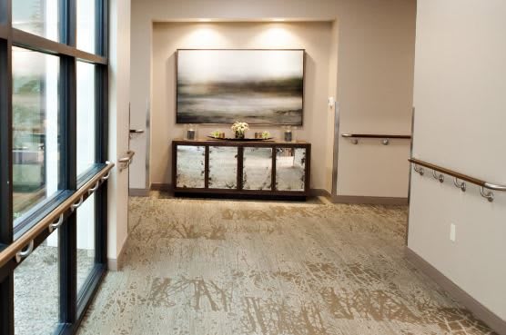 A modern hallway featuring artwork and decorative furniture.