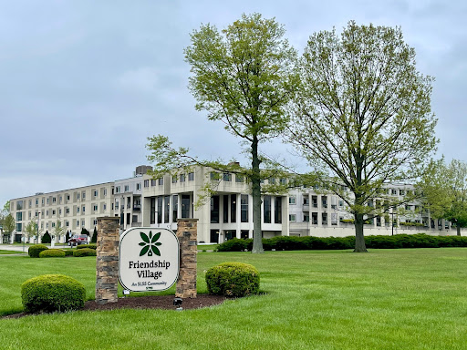 The entrance of Friendship Village, showcasing its modern architecture and landscaped surroundings.