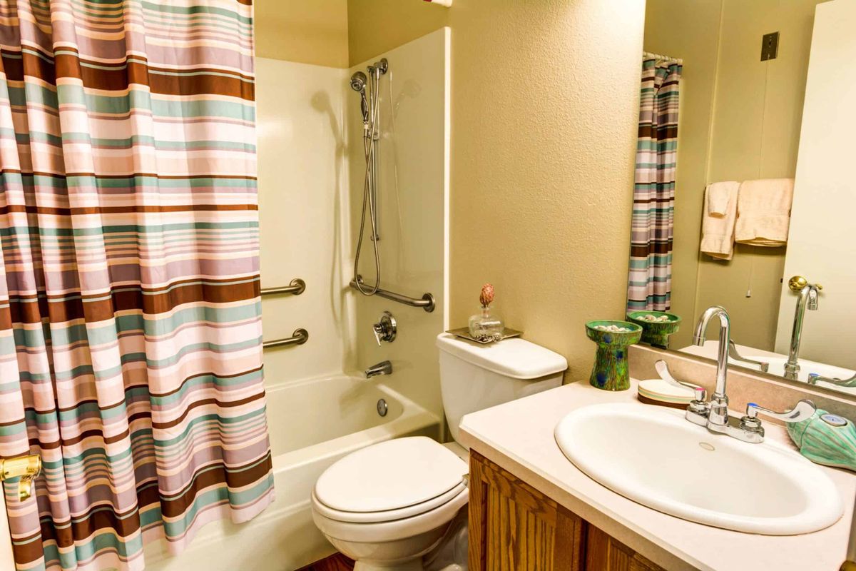 A cozy bathroom with a bathtub, shower, and striped curtain.