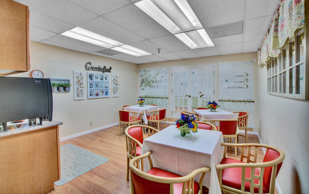 A cozy dining area with neatly arranged tables, chairs, and decorative elements.