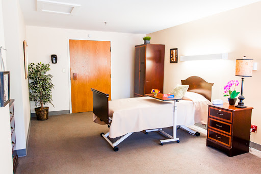A well-equipped hospital room featuring a patient bed, furniture, and a calming interior.