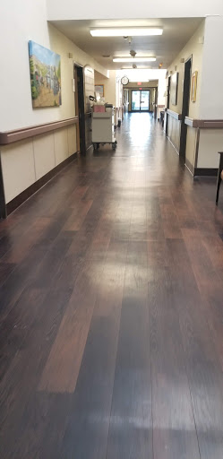 A view of a clean and well-lit wooden floor in a hallway.
